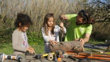 Deux enfants bricolent avec l'aide d'un animateur