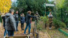 des agents sont devant un jardin et écoutent une animatrice qui leur montre les différents aménagements