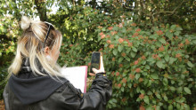 une animatrice prend des photos d'une plante pour l'identifier grace à l'application PlantNet