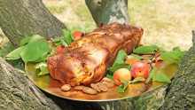 Cake sur une assiette dorée posé dans un arbre avec des abricots et des amandes autour