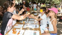 Un enfant doit reconnaître par le toucher des fruits et légumes donnés par d'autres enfants