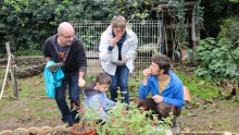 Un animateur de l'Écolothèque fait découvrir à des parents des herbes aromatiques.