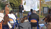 Un élu parle devant une carte de la métropole et s'adresse à un groupe