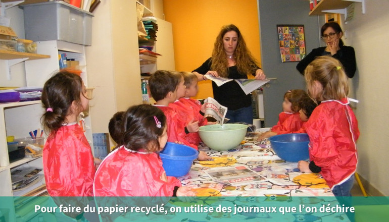 Une animatrice déchire des feuilles de papier journal pour faire du papier recyclé