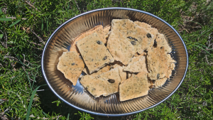 Des crackers dans un plat sont disposés sur du romarin