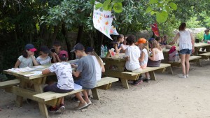 des enfants aurour de tables proposent leurs stands sur le thème de la lumière