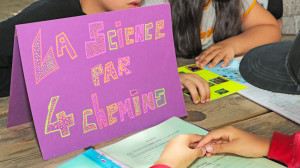 panneau posé sur une table avec écrit La science par 4 Chemins