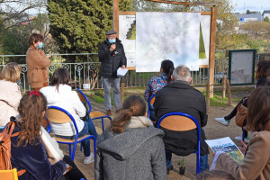 Un élu parle devant une carte de la métropole et s'adresse à un groupe